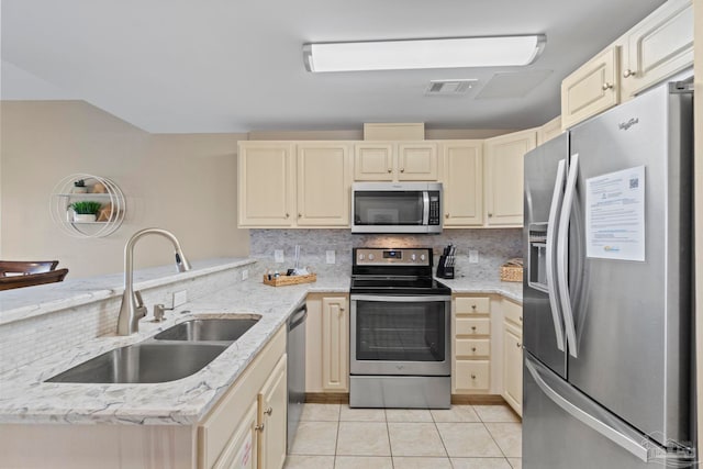 kitchen with backsplash, sink, appliances with stainless steel finishes, light tile patterned floors, and light stone counters