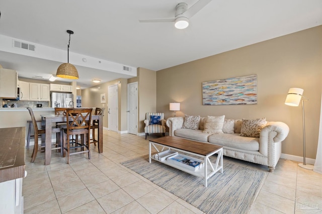 tiled living room with ceiling fan