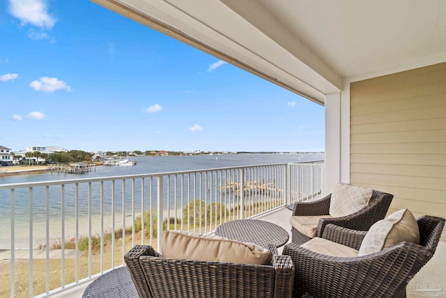 balcony featuring a view of the beach and a water view