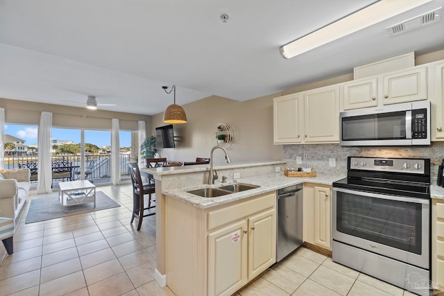 kitchen featuring sink, kitchen peninsula, stainless steel appliances, and light tile patterned flooring