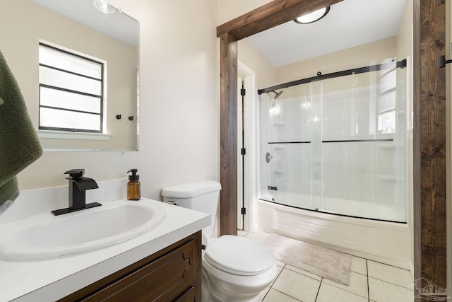 bathroom with toilet, vanity, bath / shower combo with glass door, and tile patterned floors