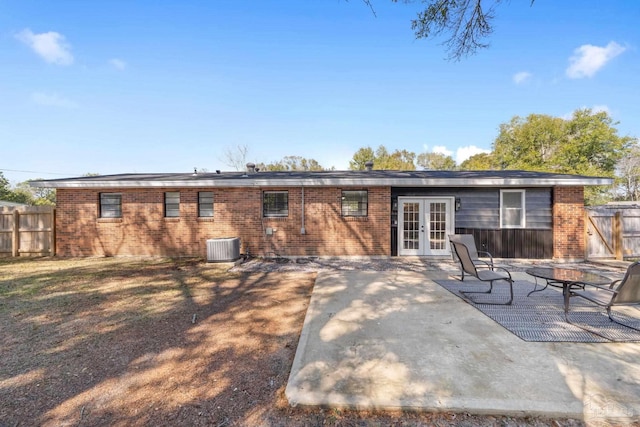 back of property with french doors, brick siding, a patio, and fence