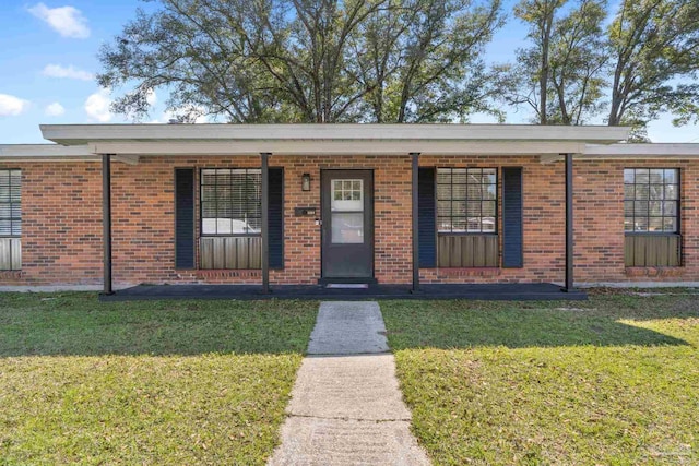 view of front facade with brick siding and a front yard