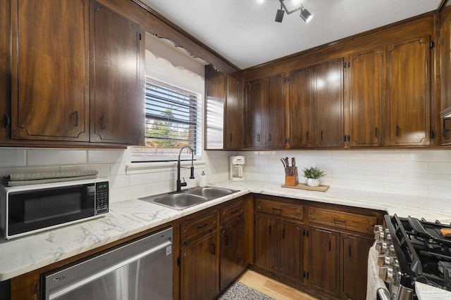 kitchen featuring stainless steel appliances, a sink, and decorative backsplash