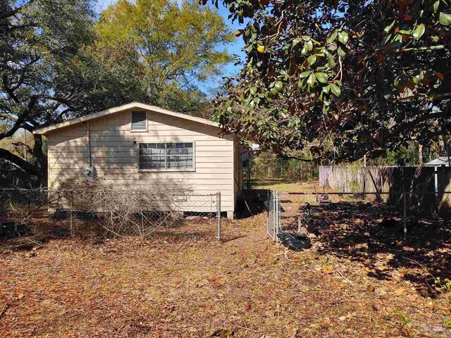view of side of home featuring fence