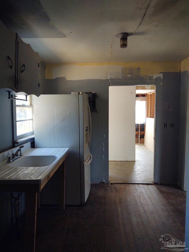 kitchen featuring tile counters, freestanding refrigerator, a sink, and hardwood / wood-style floors