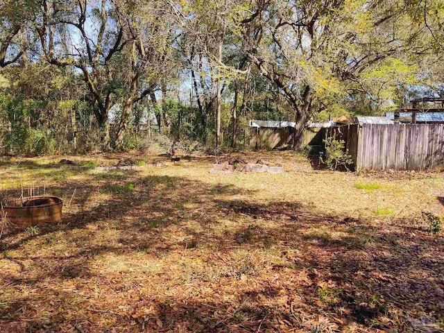 view of yard featuring fence and a view of trees