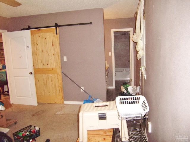 interior space with connected bathroom and a barn door