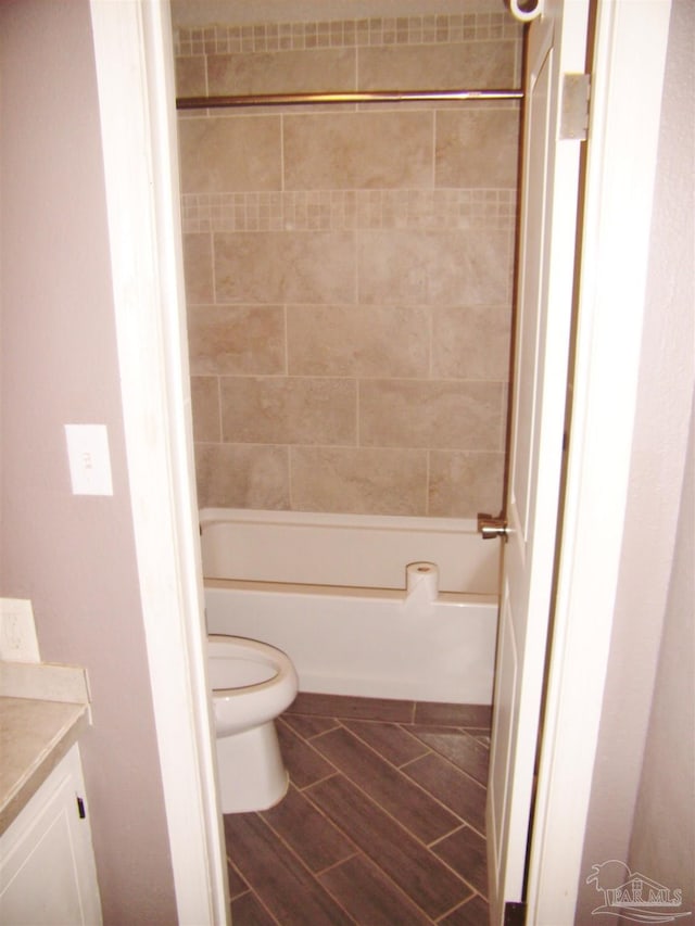 full bathroom with tiled shower / bath, vanity, and toilet