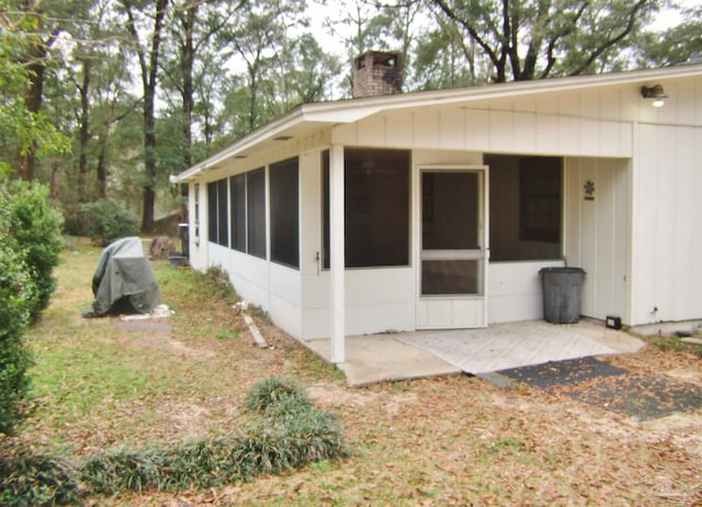 view of side of home with a sunroom and a patio