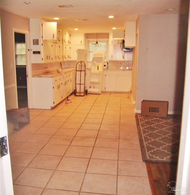 kitchen with light tile patterned floors and white cabinets