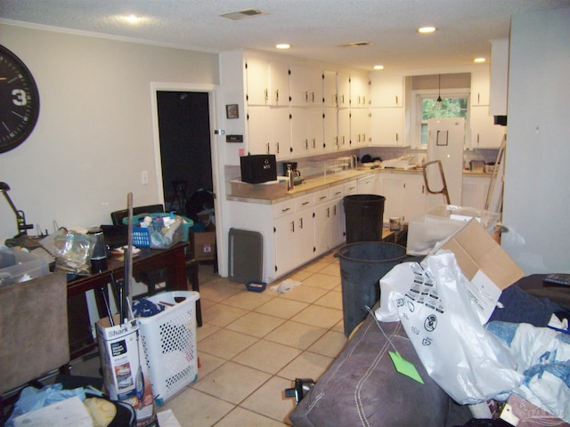 kitchen featuring white cabinetry, light tile patterned floors, a textured ceiling, and decorative backsplash