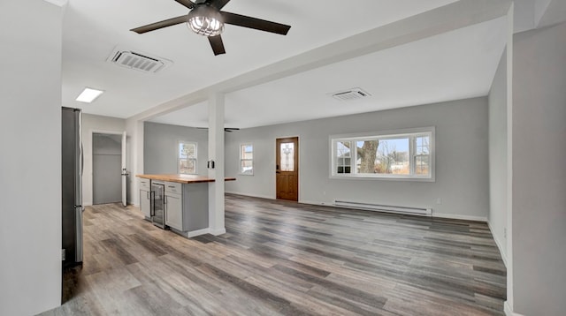 kitchen with wood counters, beverage cooler, ceiling fan, a baseboard radiator, and dark hardwood / wood-style floors