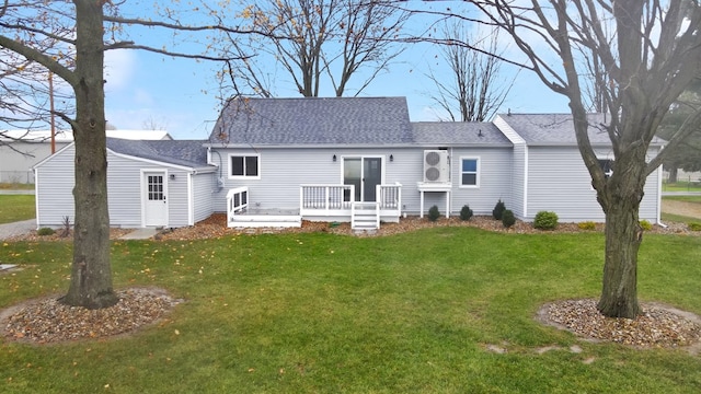 back of property with a wooden deck and a yard