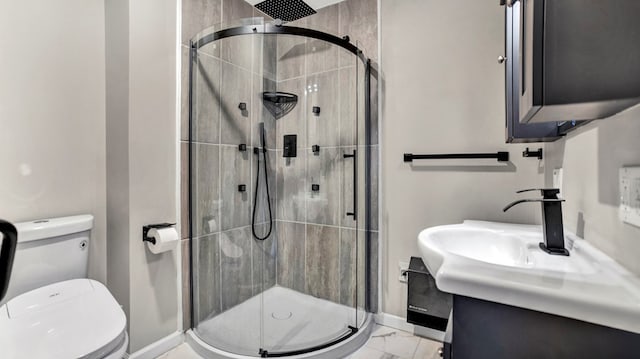 bathroom featuring vanity, toilet, and a shower with door