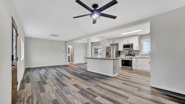 kitchen featuring white cabinets, ceiling fan, stainless steel appliances, and hardwood / wood-style flooring