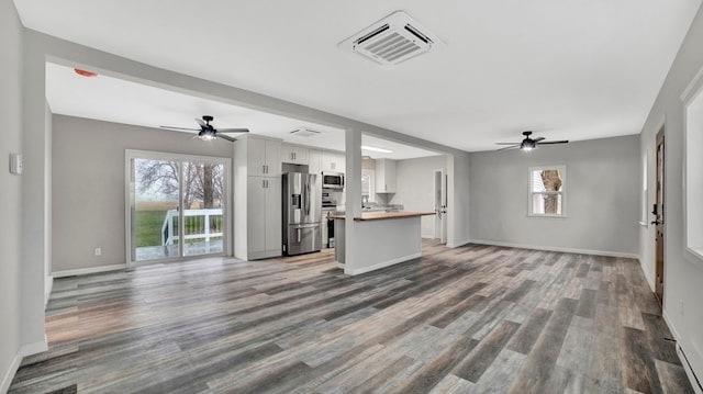 unfurnished living room with ceiling fan and wood-type flooring