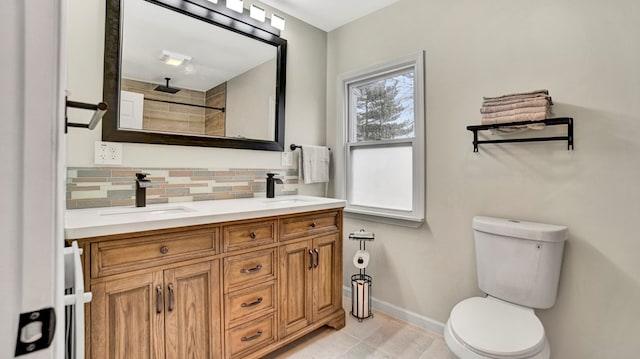 bathroom with decorative backsplash, vanity, toilet, and walk in shower