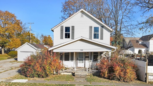 view of front of home featuring a garage, covered porch, and an outbuilding