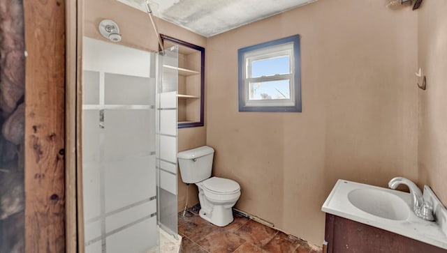 bathroom with vanity, toilet, and a shower