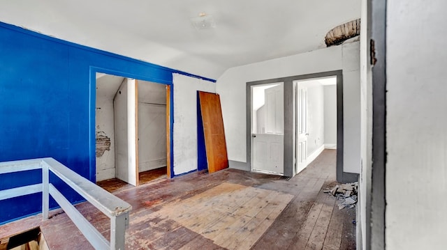 unfurnished bedroom with lofted ceiling and hardwood / wood-style flooring