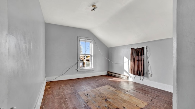 additional living space with a baseboard heating unit, wood-type flooring, and vaulted ceiling