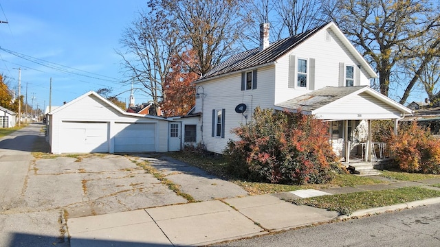 view of front of home featuring a garage and an outbuilding