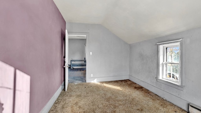 additional living space featuring carpet, lofted ceiling, and a baseboard heating unit