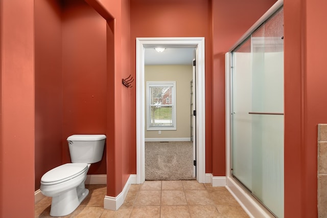 bathroom featuring tile patterned floors, toilet, and walk in shower