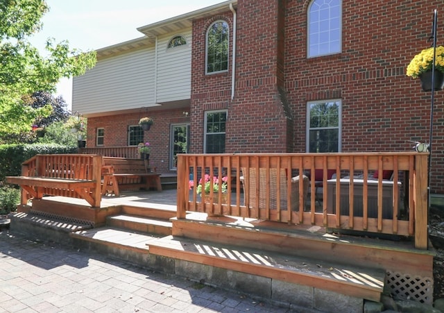 back of property with brick siding and a wooden deck