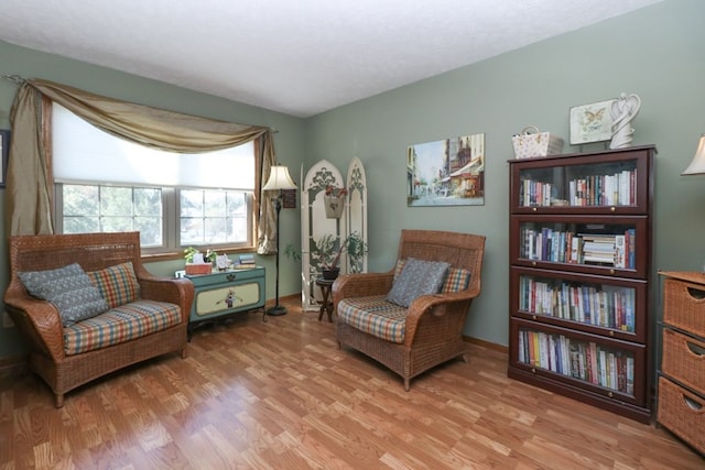 living area featuring light wood-style flooring and baseboards