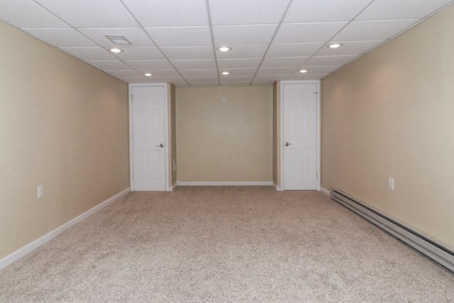 empty room with a baseboard heating unit, recessed lighting, carpet flooring, and baseboards