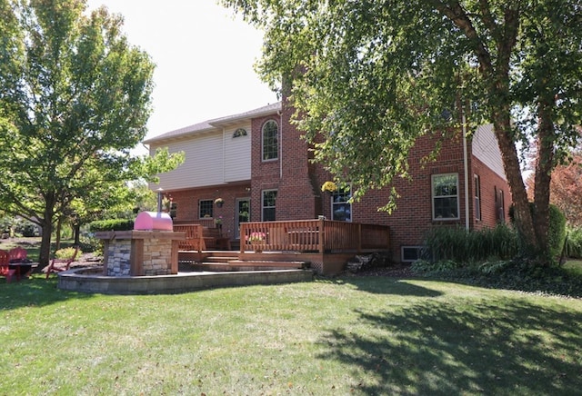 rear view of house with brick siding, a yard, and a deck