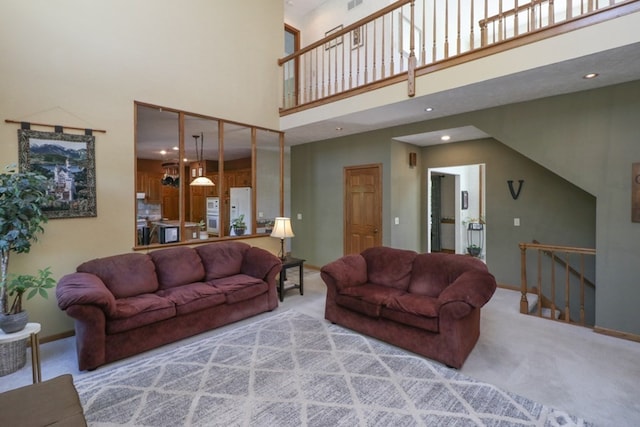 carpeted living area featuring recessed lighting, baseboards, and a high ceiling