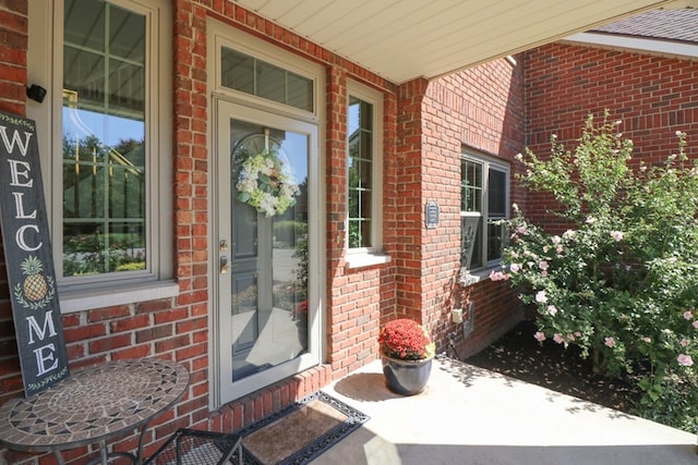 doorway to property featuring brick siding