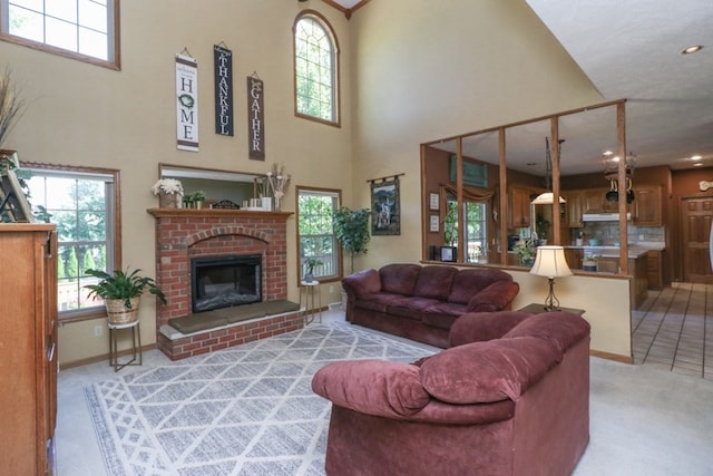 living area with plenty of natural light, a fireplace, a high ceiling, and light colored carpet