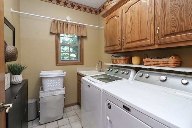 laundry room with washing machine and dryer, cabinet space, and a sink