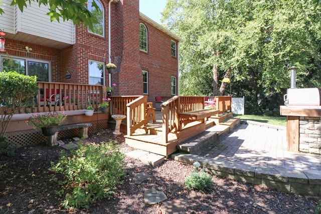 exterior space with brick siding, a chimney, and a wooden deck