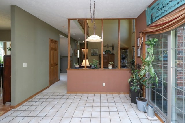 kitchen featuring hanging light fixtures, tile patterned flooring, and baseboards