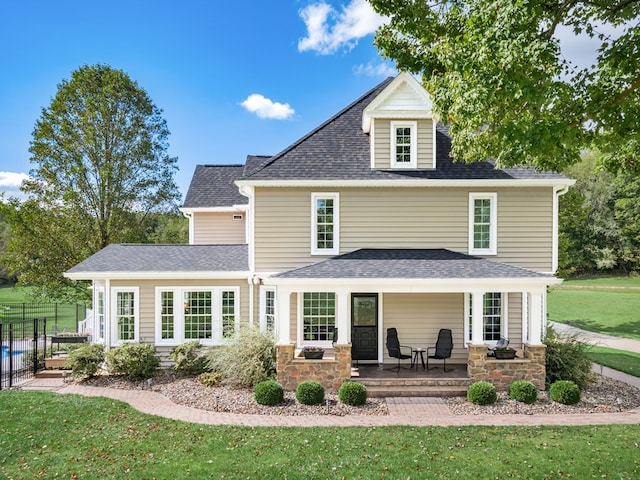 rear view of house with a porch and a lawn