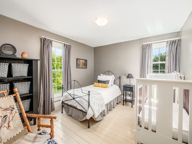 bedroom with light hardwood / wood-style flooring and multiple windows