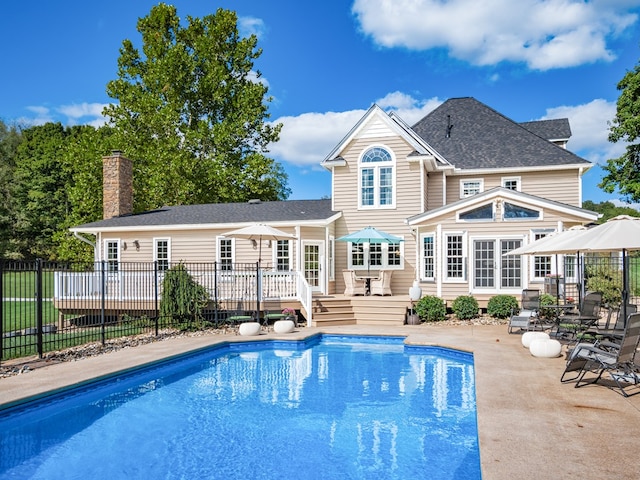 rear view of property with a patio and a pool side deck