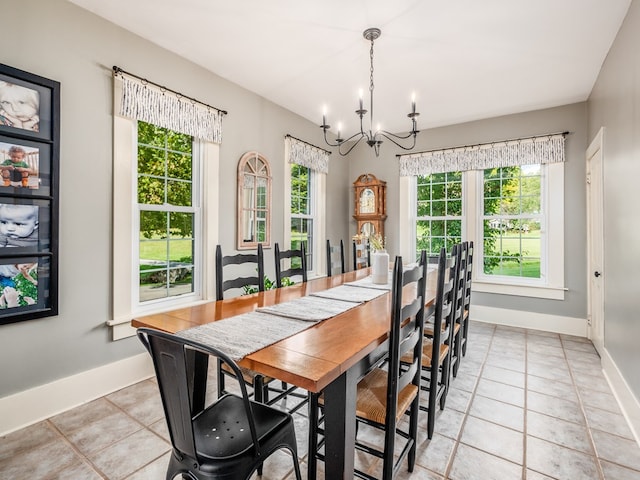 tiled dining room featuring a healthy amount of sunlight and an inviting chandelier