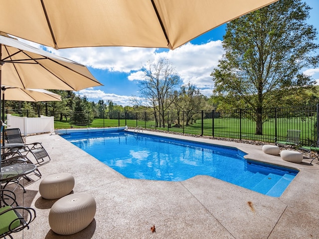 view of swimming pool featuring a yard and a patio