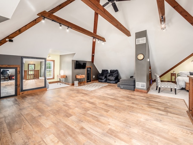 living room with beam ceiling, rail lighting, high vaulted ceiling, and light wood-type flooring