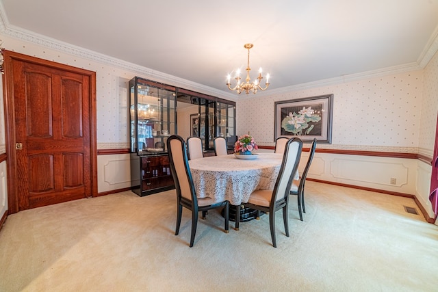 dining space with ornamental molding, light carpet, and a notable chandelier