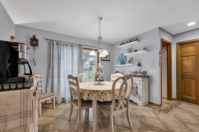 dining space featuring an inviting chandelier and baseboards