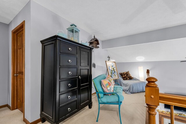 sitting room with light carpet, baseboards, and lofted ceiling