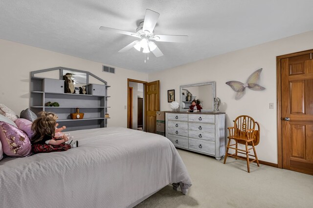 bedroom featuring baseboards, visible vents, a ceiling fan, and light colored carpet