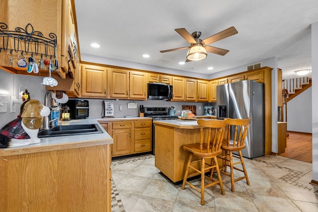 kitchen with light countertops, a kitchen island, stainless steel appliances, and visible vents